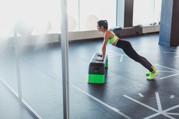 Woman performing plank on step