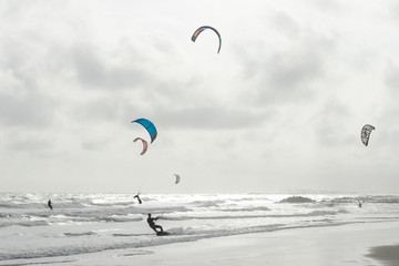 des kitesurfers sous un ciel nuageux et gris © Olivier Tabary