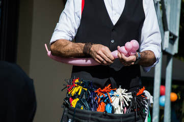 wizard creating a pink bear out of a balloon at a children's party