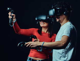 Happy friends playing video games wearing virtual reality glasses with controllers. © Fxquadro
