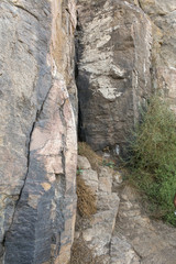 Muro de piedra con entrada de pequeña cueva