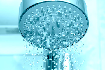 Naklejka na ściany i meble Closeup of a shower head with sprinkling water