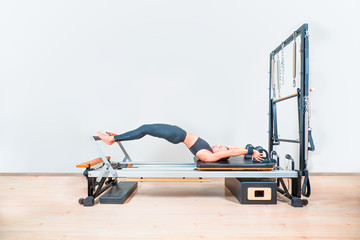 Young girl exercising on pilates reformers beds