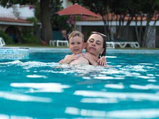 Mum with the child bathe in the pool 