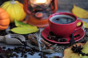 cup of coffee with cinnamon and autumn leaves on an autumn background