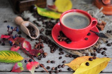 cup of coffee with cinnamon and autumn leaves on an autumn background