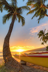 Paddling Canoe on beach in Maui at sunset