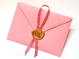 Różowa koperta z lakową złotą pieczęcią z obrączkami oraz czerwoną wstążką