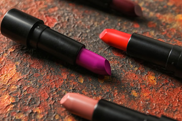 Lipsticks of different shades on color background
