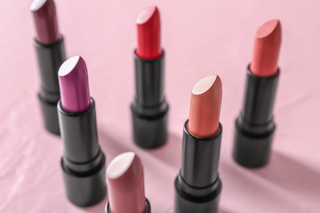 Lipsticks of different shades on color background