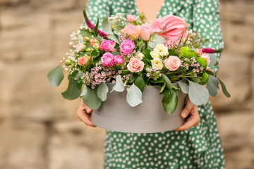 Woman holding gift box with beautiful flowers outdoors