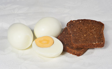 Eggs and two pieces of rye bread on the white napkin