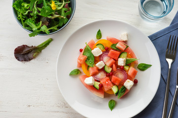 Plate with delicious watermelon salad on white table
