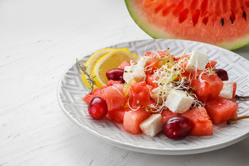 Plate with delicious watermelon salad on white table