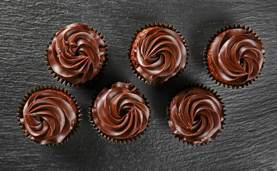 Delicious chocolate cupcakes on dark table