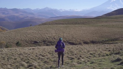 Beautiful muslim woman tourist with backpack travels in beautiful mountains,rear view