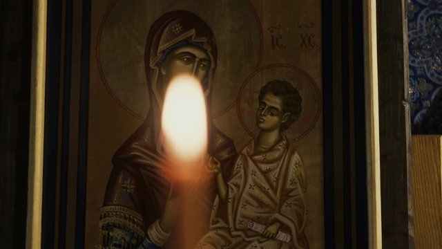 Icon of Virgin Mary and The Child Jesus 
with burning candles in an Orthodox Church. 
Eastern Europe, cca. 2017