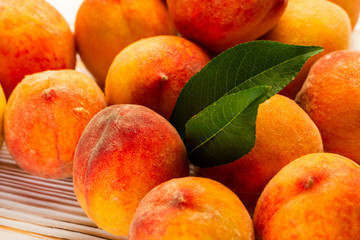 ripe peaches with leaves on the table