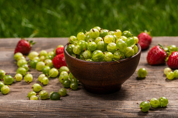 strawberries and gooseberries in the garden on the table