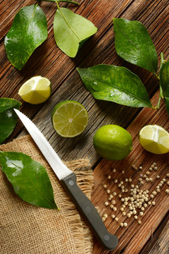 lime fruits with leaves on wooden table - tropical fruit with antioxidant properties
