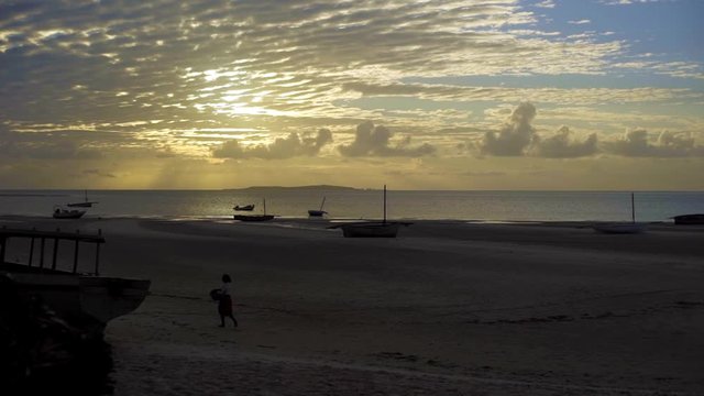 Sunset on the Horizon, with Lady walking on Beach Before Still Sea