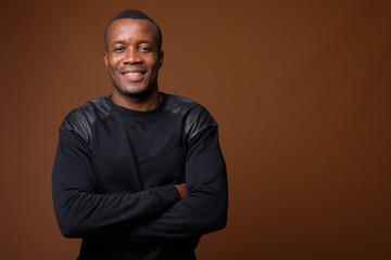 Obraz premium Studio shot of young African man against brown background