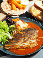 Fried sea bass with vegetables and sauce