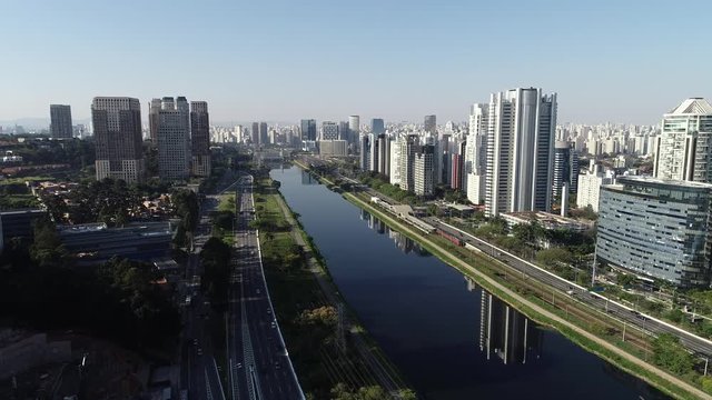 Aerial view of Marginal Pinheiros avenue, Pinheiros river, modern buildings in Sao Paulo city on a sunny day.