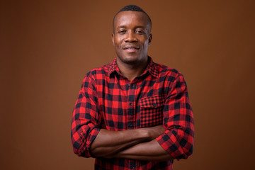 Fototapeta premium Studio shot of young African man against brown background
