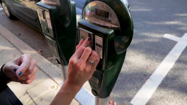 Close Shot Putting Money into a Parking Meter.