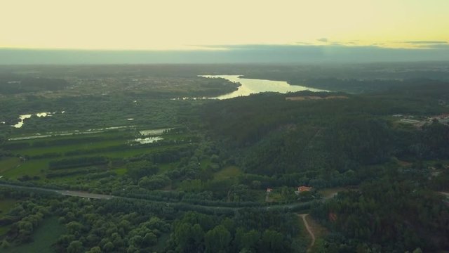 Sunset over a river flowing through a forest.