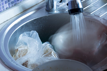 Water flowing from the faucet to the washbasin
