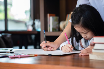 cute girl smiled and sitdown to drawing a book in the library, children concept, education concept