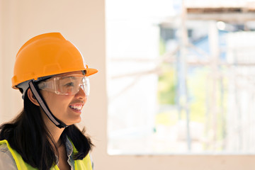 Women Engineering wearing yellow helmet and working at construction site