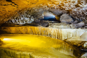Beautiful natural cave. Cascades of underground lakes in Nizhneshakuranskaya cave, Abkhazia, Georgia