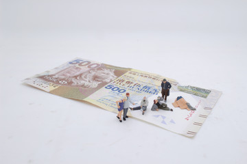 a mini beggar begs on bank note