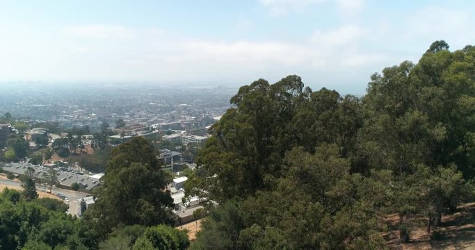 Berkeley hills aerial over trees to reveal UC Berkeley Northern California