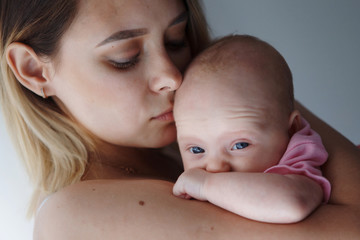 Little cute girl two months old in a pink shirt.