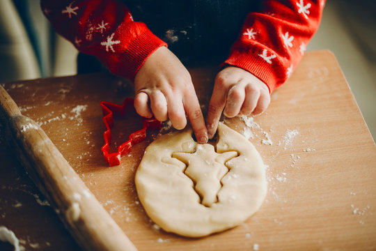 Crop kid cutting Christmas cookies
