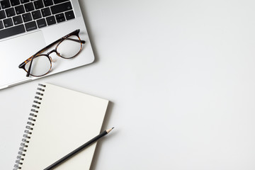 Top view desk with laptop computer notebook, pencil and plant potted on white background