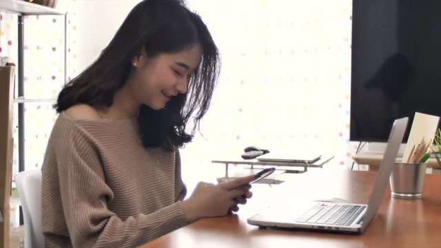 Slow motion of beautiful asian girl using mobile cellphone with smile face.