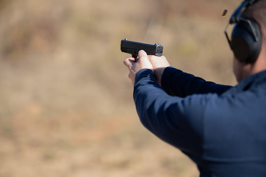 Adult male target practicing with handgun at the outdoor range in Oregon.