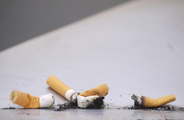 Discarded cigarettes on metallic surface
