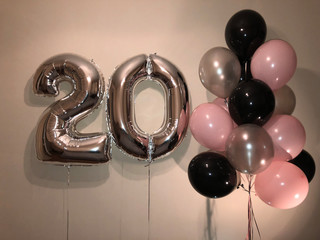 Composition of helium balloons white, pink, transparent with confetti, as well as a gold star and a large figure of twenty silver colors. Gift for 20 years for a girl