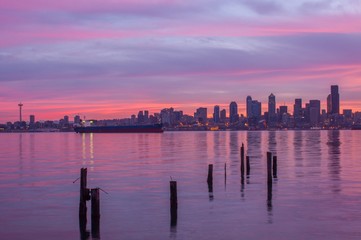 A colorful Seattle sunrise with water refleciton and bird on piling