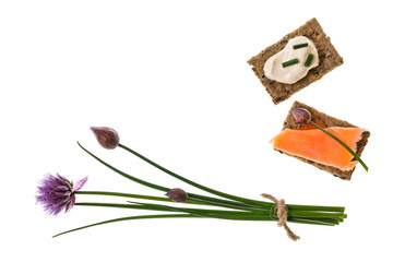 bunch of fresh chives with wholemeal crackers with salmon and sour cream