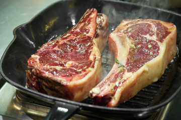 Raw fresh meat T-bone steak on grill iron pan