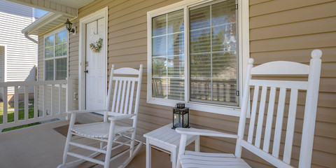 Home with rocking chairs and table on front porch