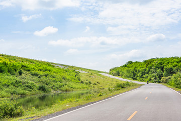 Landscape Scenic road travel on empty highway near a large reservoir with sky and clouds background.Pa Sak Jolasid Dam Thailand.