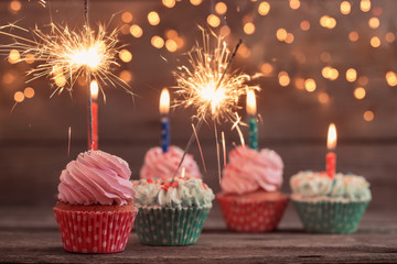 cupcake with sparkler on old wooden background